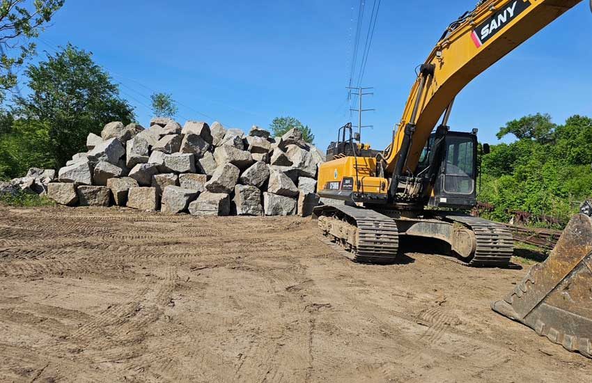 Granite Companies excavator loading granite boulders at quarry MN
